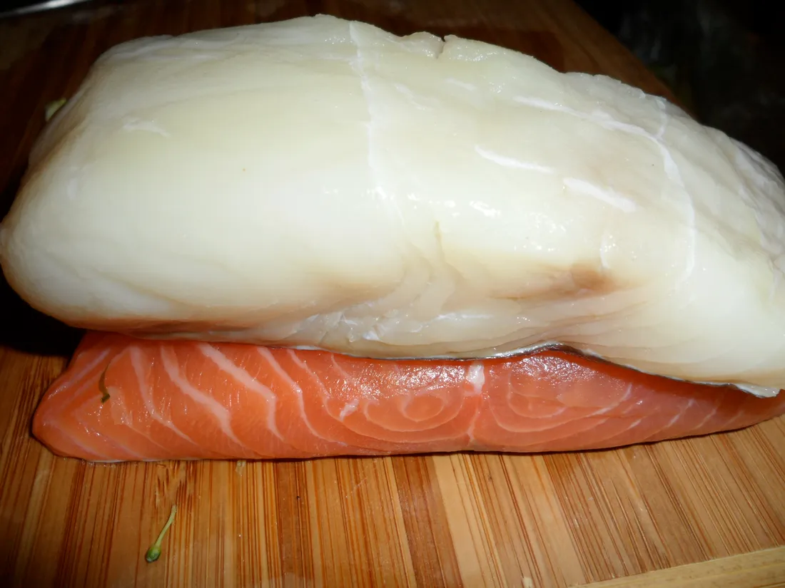 Fresh halibut fillets on a board